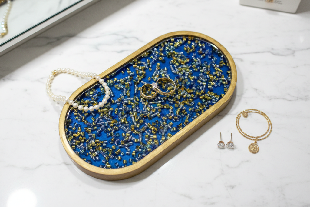 Royal blue resin tray with gold rings, pearl necklace and earrings on top